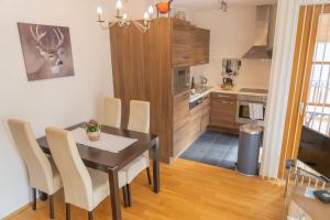 ラウリスにあるMartina 6 by SMR Rauris Apartments - inc Spa and near Gondolaのテーブルと椅子のあるキッチンとダイニングルーム +41枚の写真