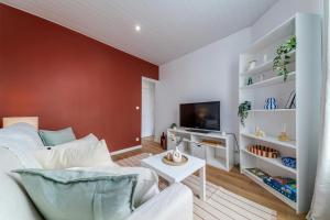 a living room with a couch and a tv at LAtelier dEpinay Terracotta - Near Paris in Épinay-sur-Seine +13 photos