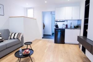 a living room with a couch and a table and a kitchen at Black White Retreat – Fontainebleau in Fontainebleau