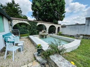 ein Hinterhof mit einem Pool mit Tisch und Stuhl in der Unterkunft Magnifique Maison dartiste La Maison Aerts in Reims