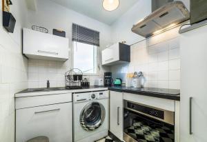a kitchen with a washer and a dishwasher at Studio Ensoleillé à Saint-Maur - Proche Paris in Saint-Maur-des-Fossés