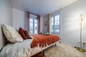 a bedroom with a bed with pillows and windows at Brown Derby Magic Stay near Disneyland in Bailly-Romainvilliers