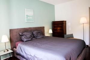 ein Schlafzimmer mit einem Bett und zwei Lampen und einer Kommode in der Unterkunft F3 - Guerin Locations Biarritz in Biarritz