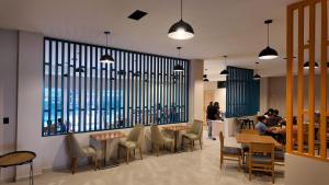 a restaurant with tables and chairs and a large window at Quality Inn Piedras Negras in Piedras Negras