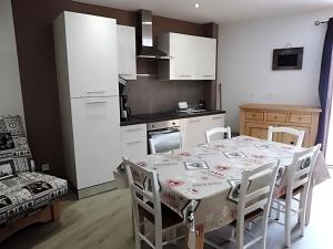 a kitchen with a table and chairs in a room at Chez-Cecile Risoul piscine et sauna pied de pistes in Risoul
