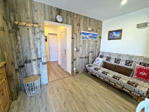 a room with a couch and a clock on a wall at Chez-Cecile Risoul piscine et sauna pied de pistes in Risoul +25 photos