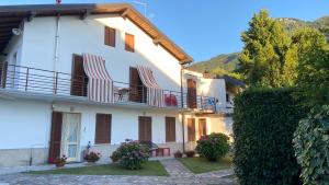 a white house with chairs on the balcony at Villa Vanda in Castelveccana