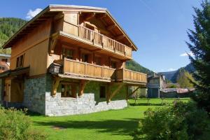 a large wooden house with a balcony on top at CASA-Chalet du Parc Cosy apartment in Tignes with garden in Tignes