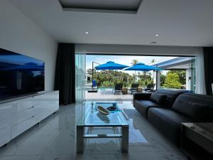 a living room with a black couch and a glass table at Villa Elena – Luxe Confort Sud de Koh Samui in Surat Thani