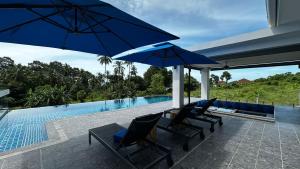 a patio with chairs and umbrellas next to a swimming pool at Villa Elena – Luxe Confort Sud de Koh Samui in Surat Thani