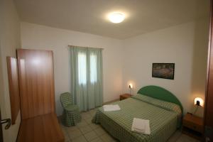 a hotel room with a green bed and a window at Residence Club Barbara in Ostuni