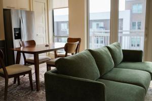 un soggiorno con un divano verde e un tavolo di Pool View Downtown Near Stadiums a Houston Altre 10 foto