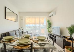 a dining room with a table with plates and glasses at Appartement Cosy à Vence avec Piscine & Parking in Vence