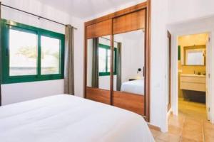 a bedroom with a white bed and a large mirror at Casa Roma in Puerto del Carmen +13 photos