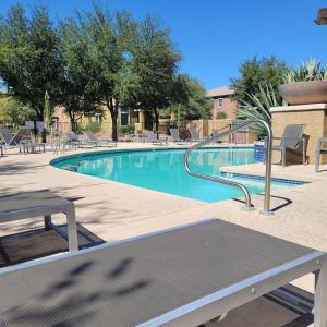 a swimming pool with a picnic table and chairs at VILLA Verde Surprise Stadium - Resort Living in Surprise