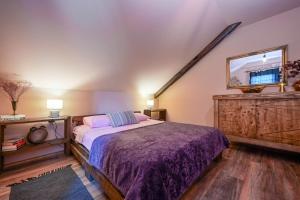 a bedroom with a bed with a purple bedspread at Chill House Keti in Kuzminec-Veternički +43 photos