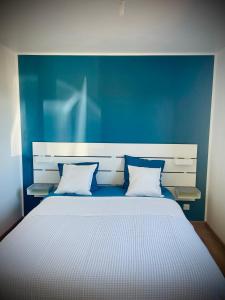 a bedroom with a large bed with a blue wall at La Belle Noiera in Bretenoux