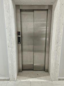 a large metal elevator door in a building at Tůma Family Apartment in Golem