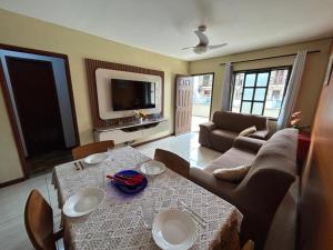 una sala de estar con una mesa y un sofá en Casa em frente a Praia das Dunas, Cabo Frio - RJ, en Cabo Frío
