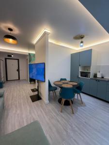 a living room with a table and chairs and a kitchen at Alexander Studio White Titanic in Mamaia Sat/Năvodari