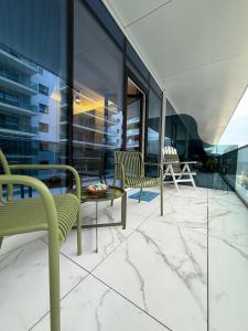 a balcony with chairs and a table on a building at Alexander Studio White Titanic in Mamaia Sat/Năvodari +45 photos