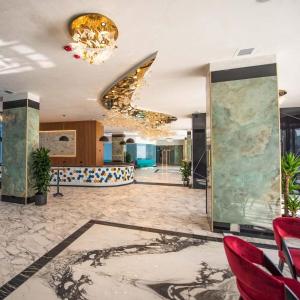 a lobby with red chairs and a chandelier at Alexander Studio White Titanic in Mamaia Sat/Năvodari