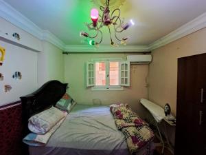 a bedroom with a bed and a chandelier at KENZY Apartment in Alexandria