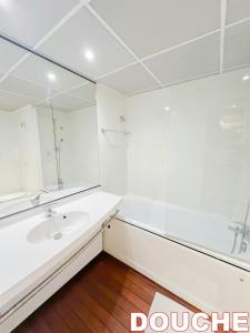 a white bathroom with a sink and a mirror at 5 minutes du Zénith - Studio Chic in Pantin