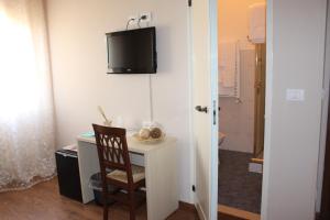 a room with a desk with a chair and a tv on the wall at B&B I' Chivi in Incisa in Valdarno