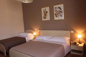 two beds in a hotel room with two lamps at B&B I' Chivi in Incisa in Valdarno