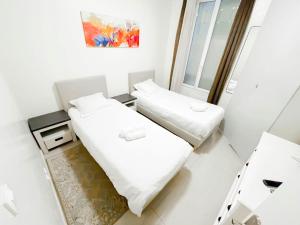 two beds in a small room with a mirror at 5 minutes de Paris T2 cocon village dIvry in Ivry-sur-Seine