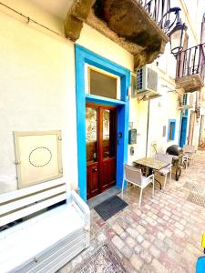 a house with a blue door and a table at Poseidone in Lipari