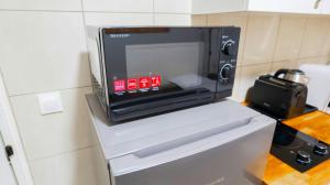 a microwave oven sitting on top of a refrigerator at 5 minutes de Paris T2 cocon village dIvry in Ivry-sur-Seine