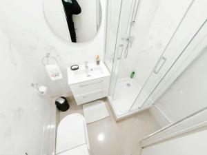 a white bathroom with a sink and a mirror at 5 minutes de Paris T2 cocon village dIvry in Ivry-sur-Seine +12 photos