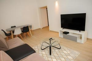 a living room with a couch and a flat screen tv at Grand T2 proche Créteil Soleil et métro ! in Créteil