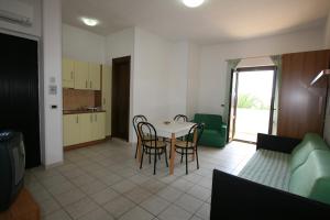 a kitchen and a living room with a table and chairs at Residence Club Barbara in Ostuni