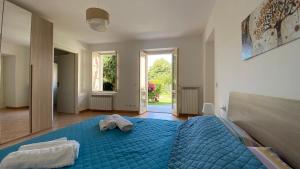 a bedroom with a blue bed with two towels on it at Villa Vanda in Castelveccana +10 photos