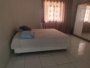 a bedroom with a bed and a window and a mirror at Casa aconchegante in São Raimundo Nonato