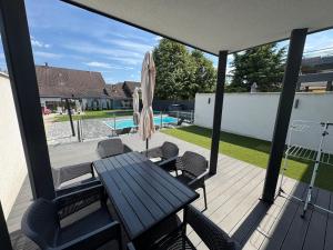 a patio with a table and chairs and an umbrella at Bala-Home Apartments & Pool in Balatonboglár +12 photos