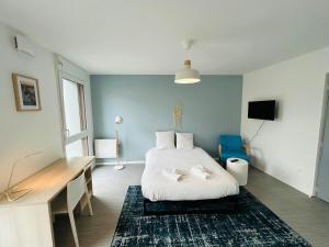 a bedroom with a bed and a desk in it at We Live In R - Suite 201 in Reims +2 photos
