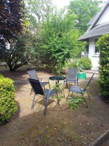 three chairs and a table in a yard at Ferienhaus Lukas in Zinnowitz