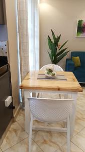 a dining room table with a white chair and a table at Lerato's Apartments in Kampala