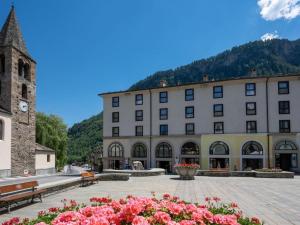 プレ・サン・ディディエにあるhost privato Residence Universoの時計塔と花の大きな建物