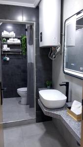 a bathroom with a white sink and a toilet at Studio Tetouan in Deroua +19 photos
