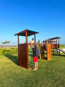 Un uomo in piedi davanti a un parco giochi di Departamento Lujoso #1504 en Karibao Resort Town a Playas