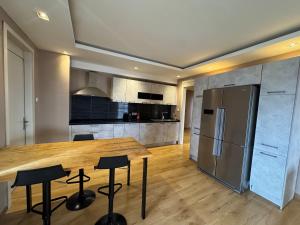 a kitchen with a wooden table and a refrigerator at Bel appartement F4 in Dakar +21 photos