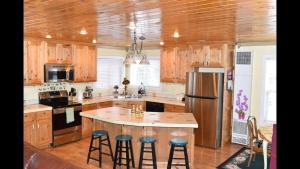 a kitchen with wooden cabinets and a island with bar stools at Neil's Yellowstone Getaway -Boating-Fishing nearby in Island Park