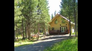 a yellow house in the middle of a forest at Neil's Yellowstone Getaway -Boating-Fishing nearby in Island Park