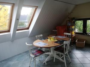 einen Tisch und Stühle in einem Zimmer mit Fenstern in der Unterkunft Apartment at the Knappensee in Groß Särchen in Neufriedersdorf