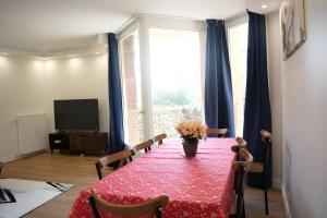 a dining room with a table with a vase of flowers on it at T5 spacieux au Bord du Lac Créteil in Créteil